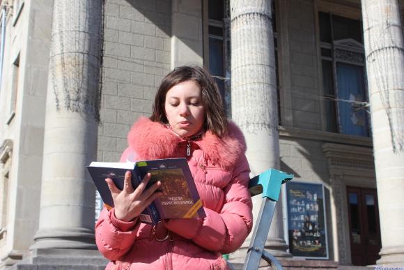 Фото дня: просто в Центрі дівчина на драбині читала книгу, фото №1 на сайті 20minut.ua